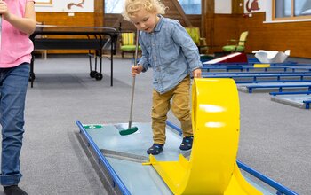 Kleinkind beim Minigolfen