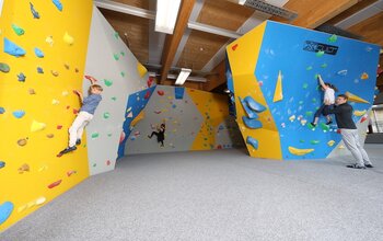 Kinder klettern auf der Boulderwand