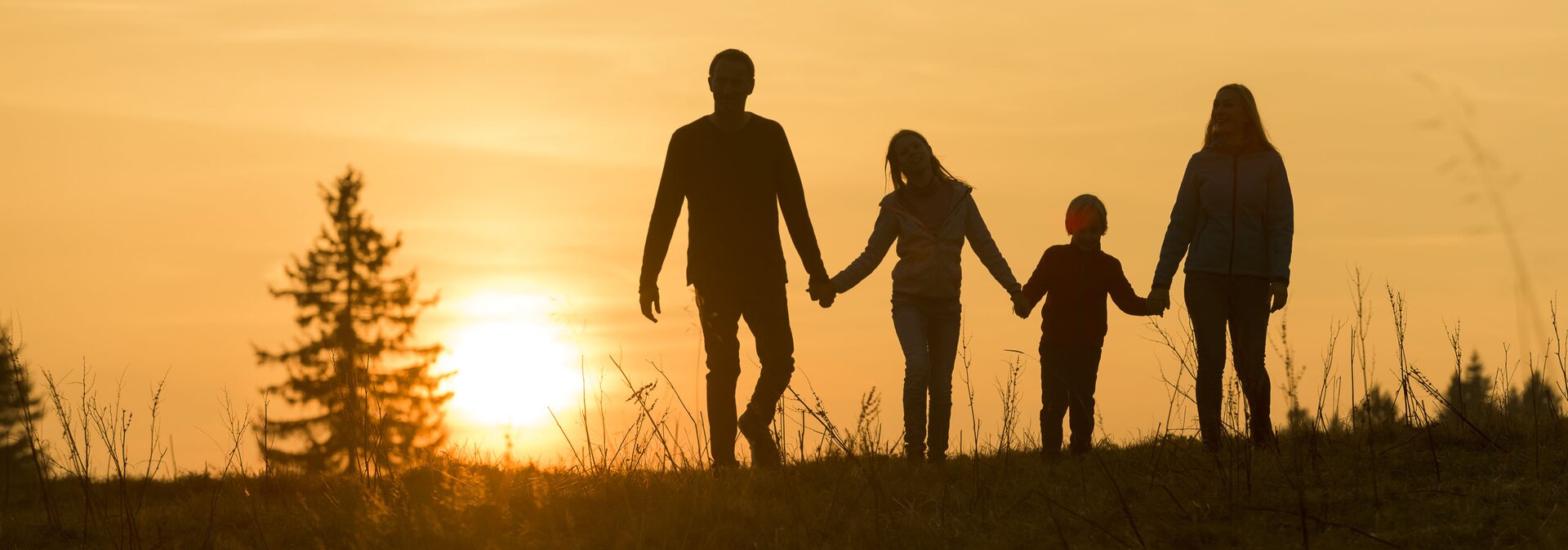 Familie wandert im Sonnenuntergang