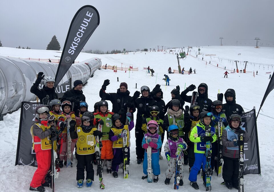 Skikursteilnehmer mit Skilehrern